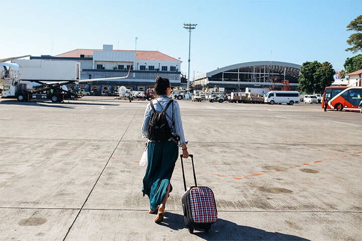 Woman at Bali airport with suitacse by Lechatnoir